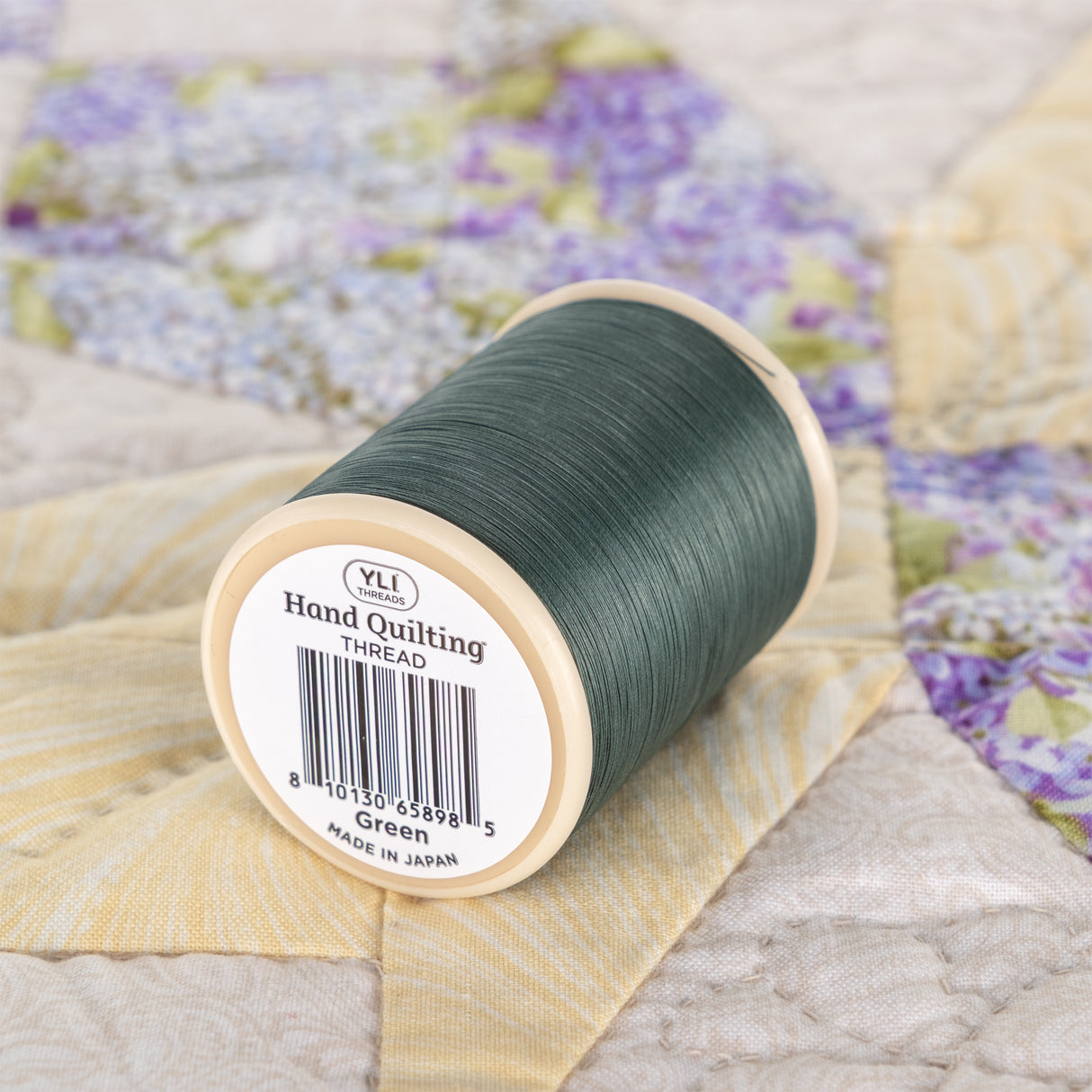 yli threads hand quilting thread green spool on quilt