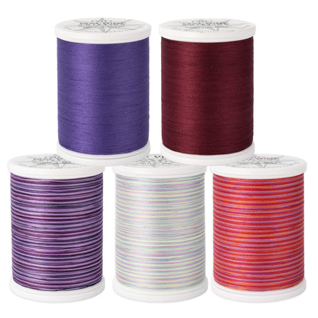 Red and purple spools of cotton Machine Quilting Thread by YLI Threads