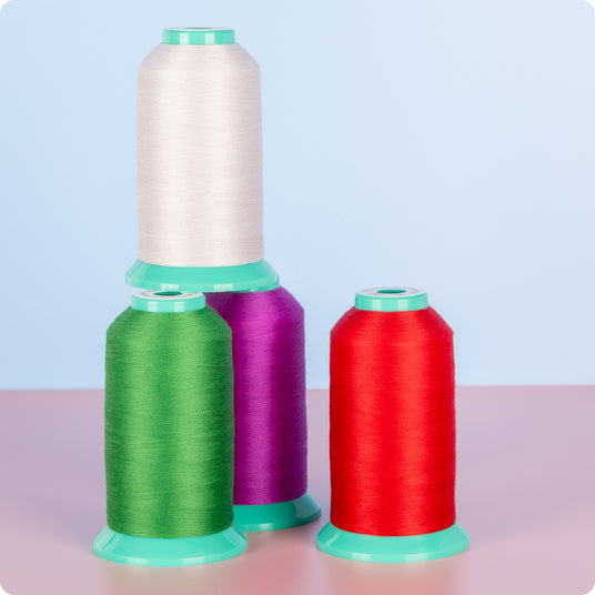 cones of perfection polyester thread in front of blue background