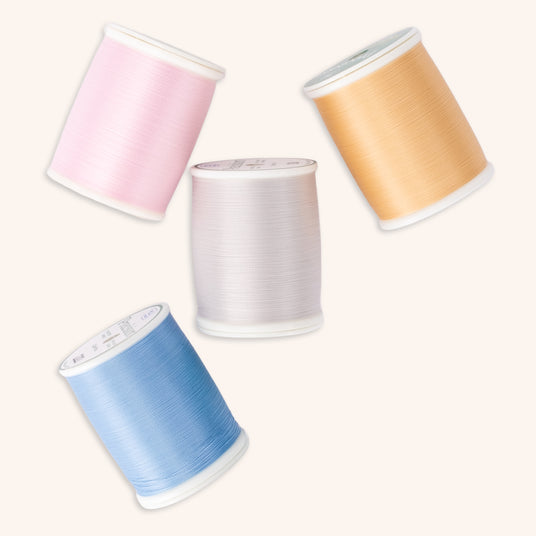 four spools of colorful precision polyester thread