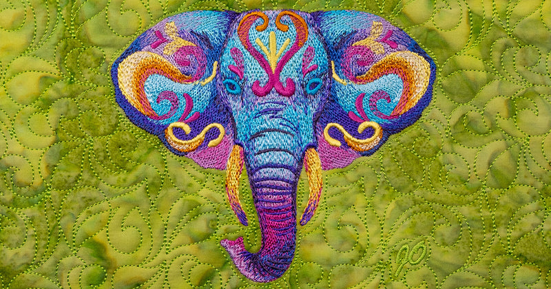 Colorful embroidered elephant design on a textured green fabric background