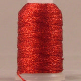 Red metallic thread on white plastic spool, shimmery finish with loose thread end visible