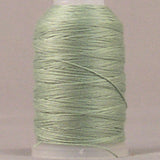 Soft green 12 wt jeans stitch thread wound on white plastic spool against neutral background