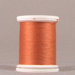 Orange thread wound on white plastic spool with visible thread layers and smooth finish