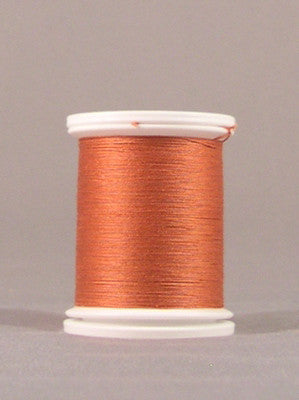 Orange thread wound on white plastic spool with visible thread layers and smooth finish