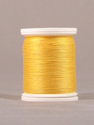 Yellow gold thread wound on white plastic spool with visible thread texture and smooth finish
