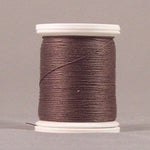 Dark brown thread wound on white plastic spool against neutral background