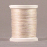Cream-colored thread on white plastic spool with visible thread windings