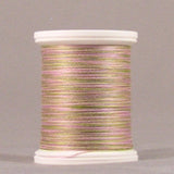 Variegated pink and green thread wound on white plastic spool against neutral background