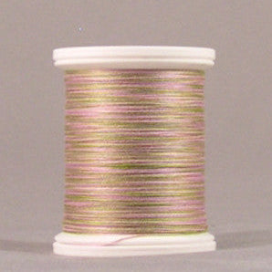 Variegated pink and green thread wound on white plastic spool against neutral background
