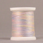 Variegated pastel thread in pink, purple, and yellow tones wound on white plastic spool