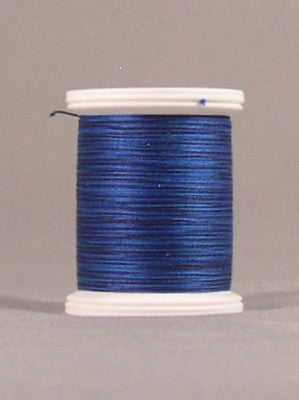 Blue thread spool with white plastic ends, showing tightly wound hyacinth blue thread on a neutral background