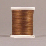 Brown thread wound on white plastic spool against neutral background