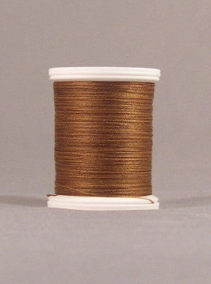 Brown thread wound on white plastic spool against neutral background
