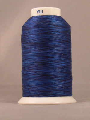 Blue variegated 24 wt thread on white cone spool with YLI label, showing deep navy to royal blue color variations