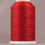 Red embroidery thread on white cone spool with YLI label, showing smooth wound thread in bright red Indian Paintbrush color