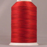 Red embroidery thread on white cone spool with YLI label, showing smooth wound thread in bright red Indian Paintbrush color