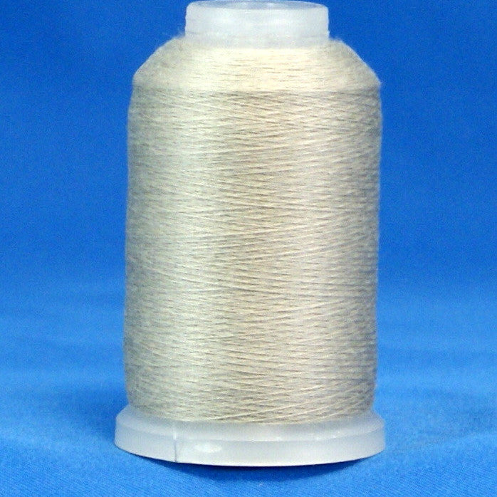 Gray thread wound on white plastic cone against blue background