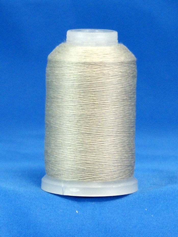 Gray thread wound on white plastic cone against blue background
