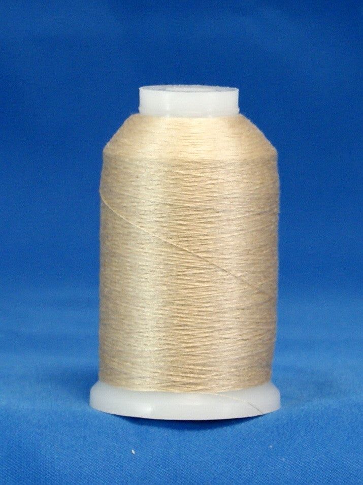 Natural colored thread wound on white plastic cone against blue background