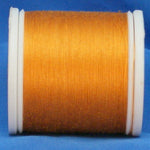Gold thread on white plastic spool against blue background