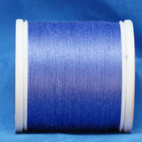 Lilac purple thread wound on white plastic spool against blue background