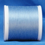 Light blue thread wound on white plastic spool against blue fabric background