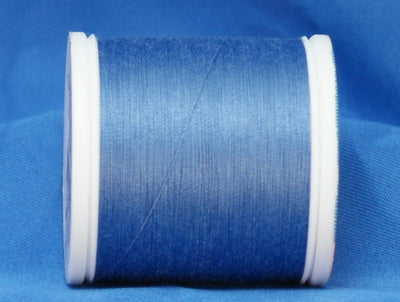 Medium blue 60 weight thread on white plastic spool against blue background