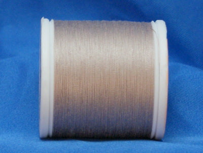 Light taupe thread wound on white plastic spool against blue background
