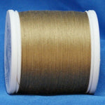 Light brown thread on white plastic spool against blue fabric background