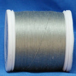 Gray thread wound on white plastic spool against blue background