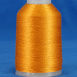 Golden orange embroidery thread wound on white plastic cone against blue background