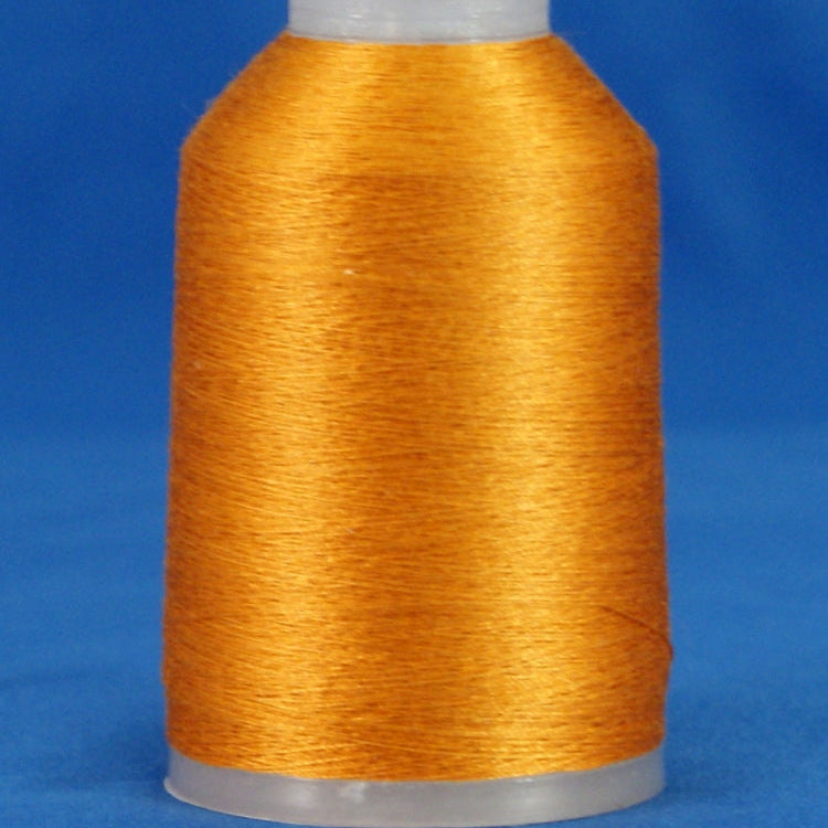 Golden orange embroidery thread wound on white plastic cone against blue background