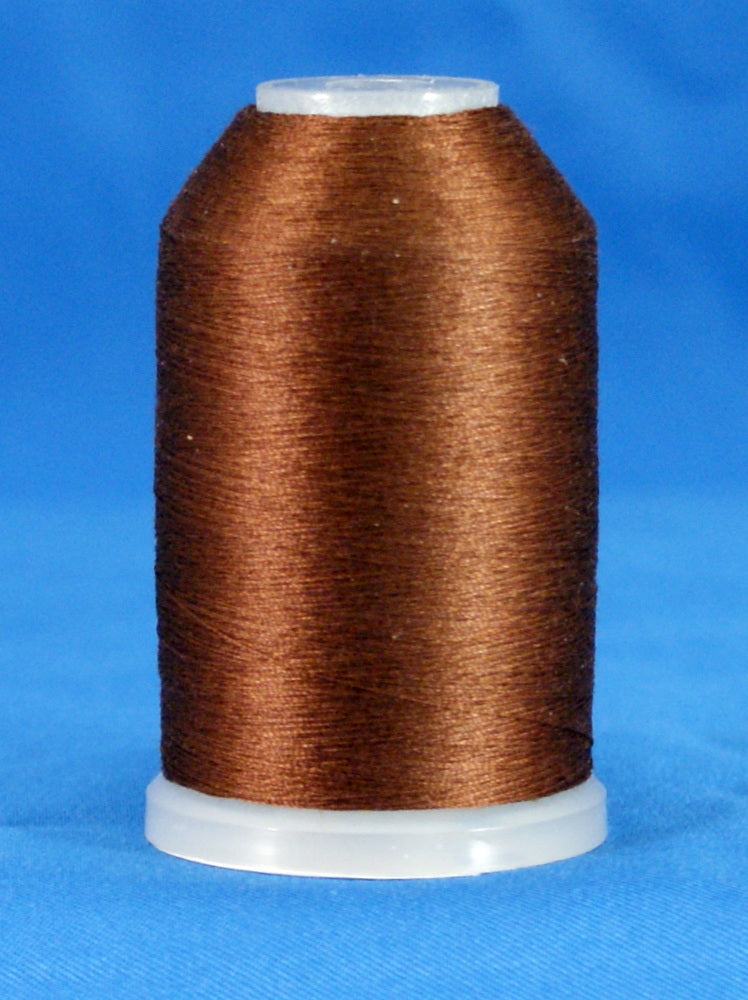 Brown thread wound on white plastic cone with tapered shape against blue background