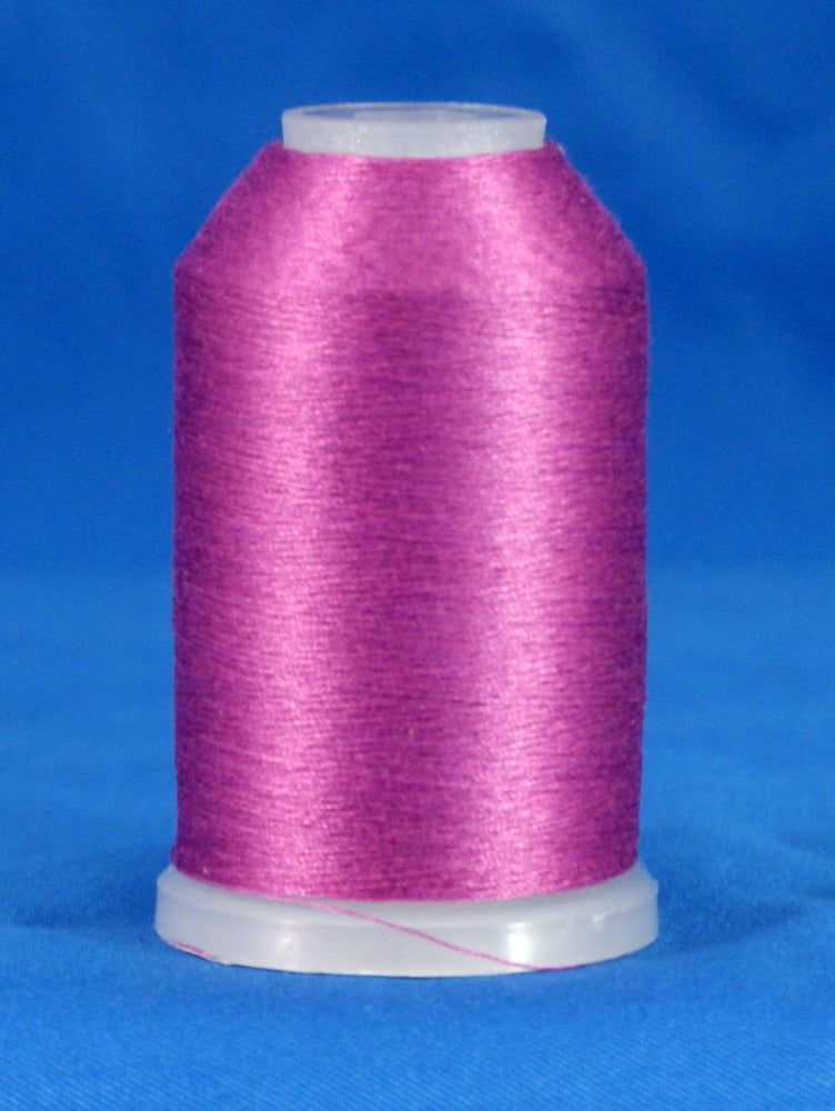 Pink embroidery thread cone with white plastic top and bottom against blue background