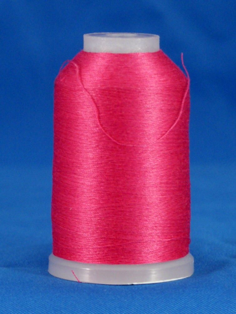 Pink fuschia thread wound on white plastic cone against blue background