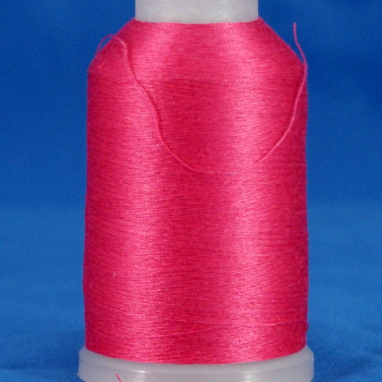 Pink fuschia thread wound on white plastic cone against blue background