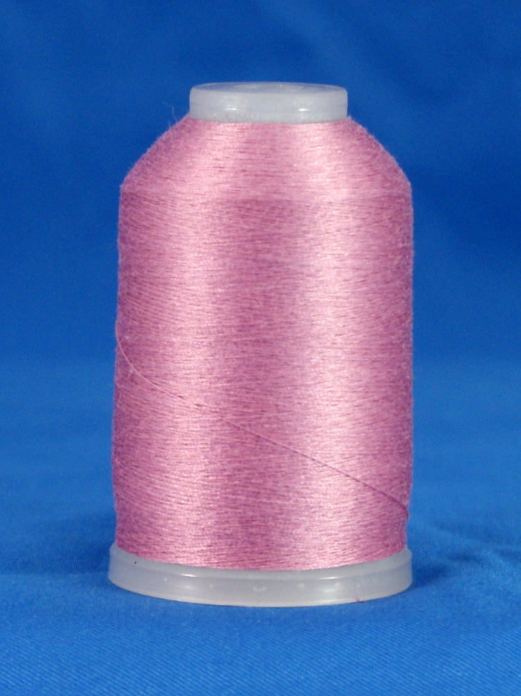 Pink thread wound on white plastic cone against blue background