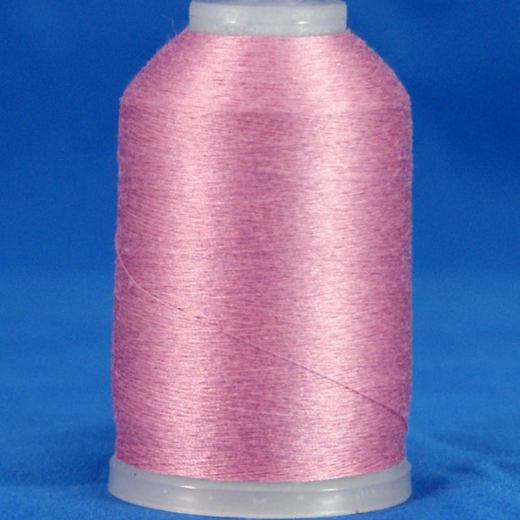 Pink thread wound on white plastic cone against blue background