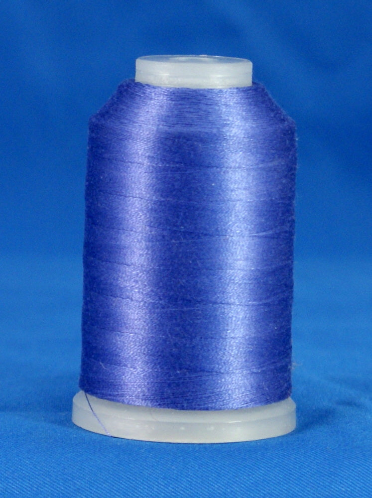 Lilac purple thread wound on white plastic cone against blue background