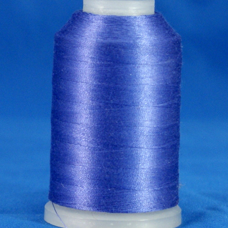 Lilac purple thread wound on white plastic cone against blue background