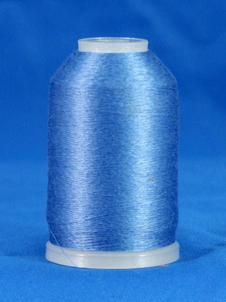 Blue embroidery thread wound on white plastic cone against bright blue background