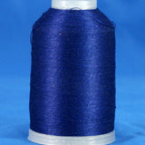 Navy blue thread wound on white plastic cone against blue background
