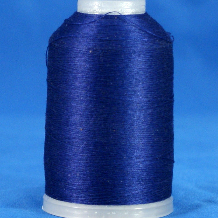 Navy blue thread wound on white plastic cone against blue background