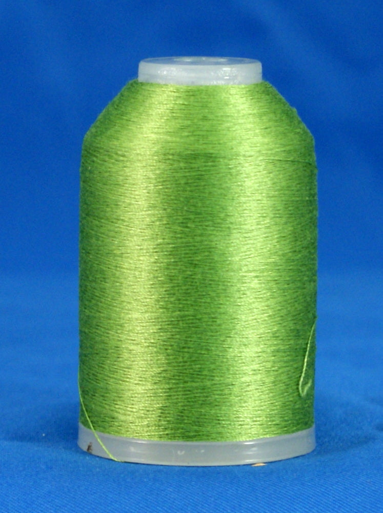 Spring green embroidery thread wound on white plastic cone against blue background