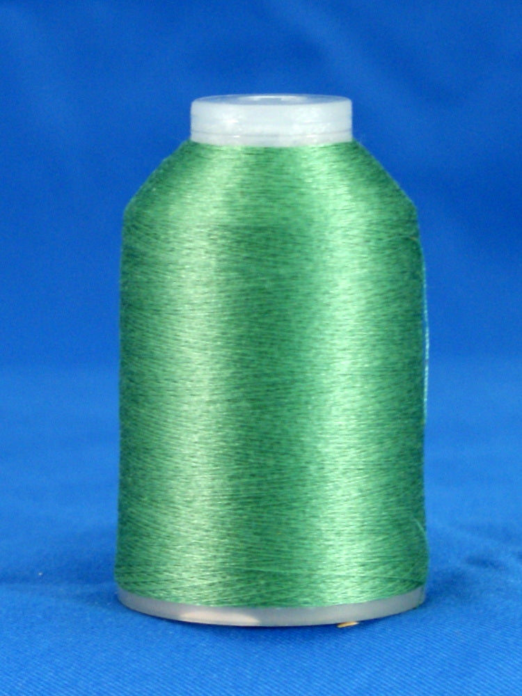 Green thread cone with white plastic cap and base against blue background