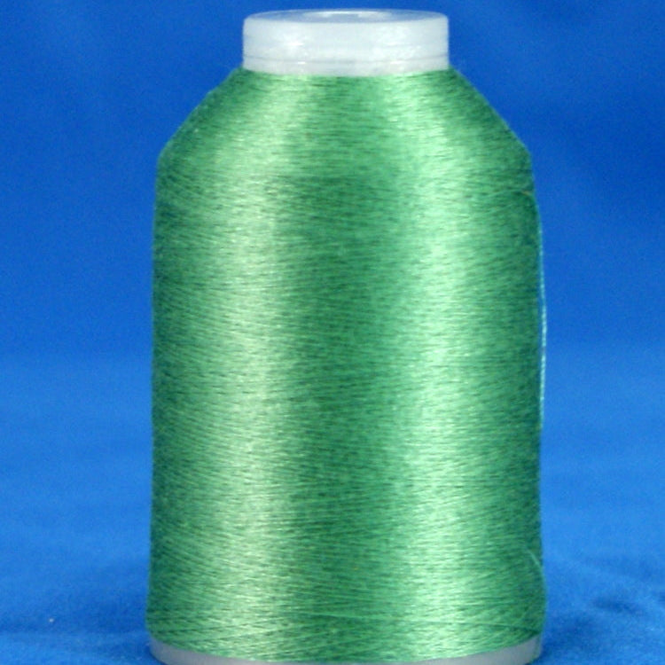 Green thread cone with white plastic cap and base against blue background