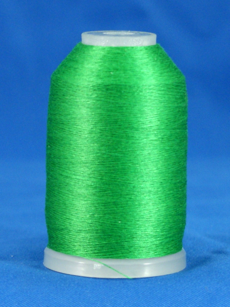 Kelly green thread wound on white plastic cone spool against blue background