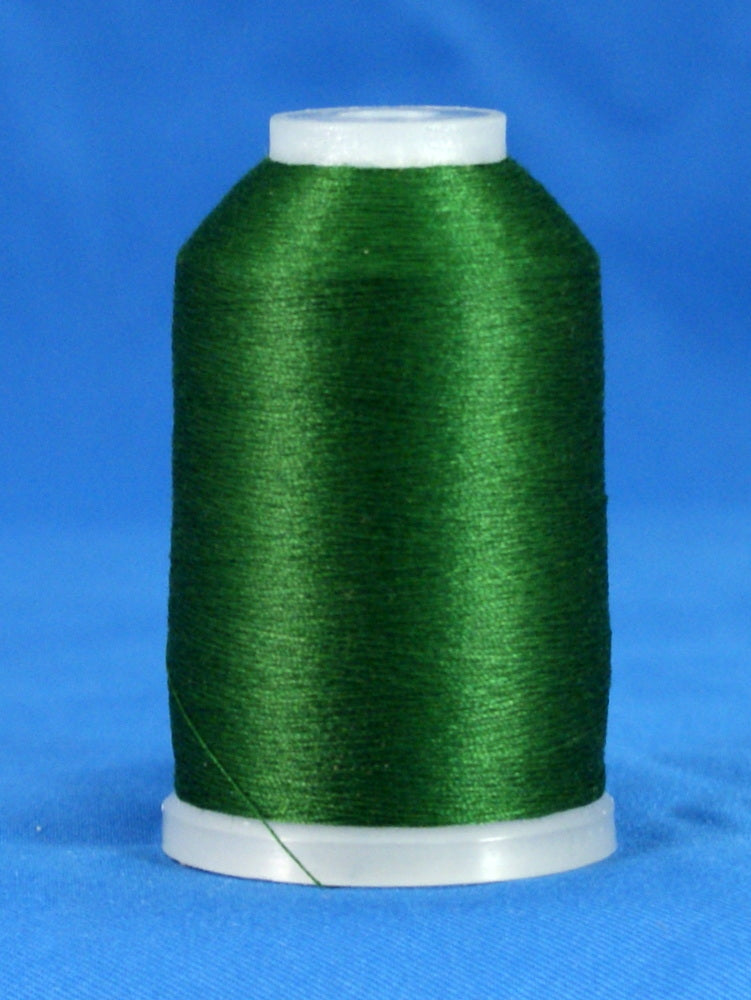 Hunter green embroidery thread wound on white plastic cone against blue background