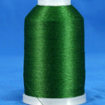 Hunter green embroidery thread wound on white plastic cone against blue background
